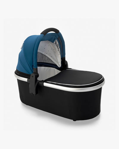 A sleek modern mockingbird-prod baby bassinet stand in black and blue with a transparent mesh panel on a white background. #color_sea