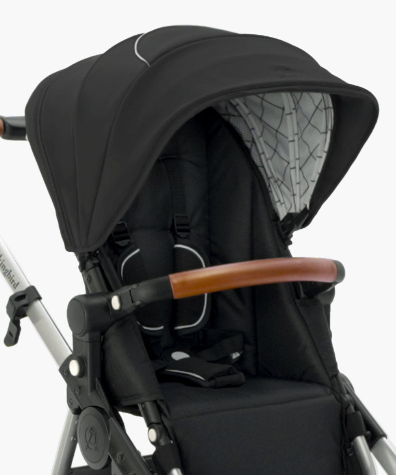 Close-up of a modern black mockingbird-prod Mockingbird stroller with an Extra Stroller Canopy 2.0, brown handlebar, and white frame. #color_black