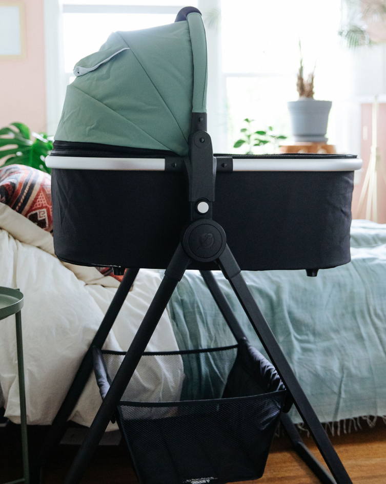 Mockingbird bassinet in sage green in a bedroom