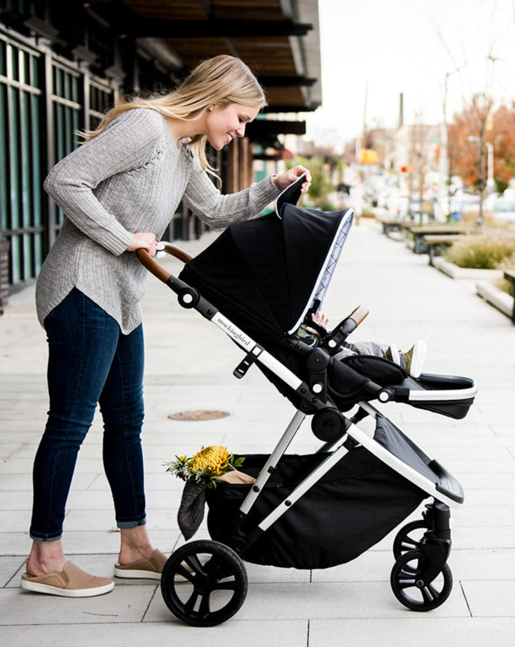 Woman looking inside peekaboo window of a Mockingbird Stroller canopy
