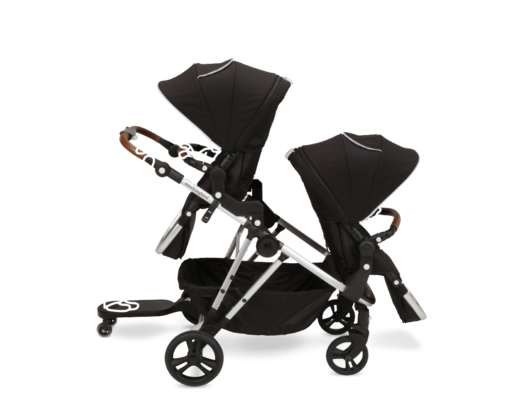 A black double stroller with modern design featuring large wheels, dual sun canopies, and a side-by-side seating arrangement.