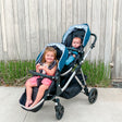 two kids in Mockingbird single to double stroller outside in front of fence
