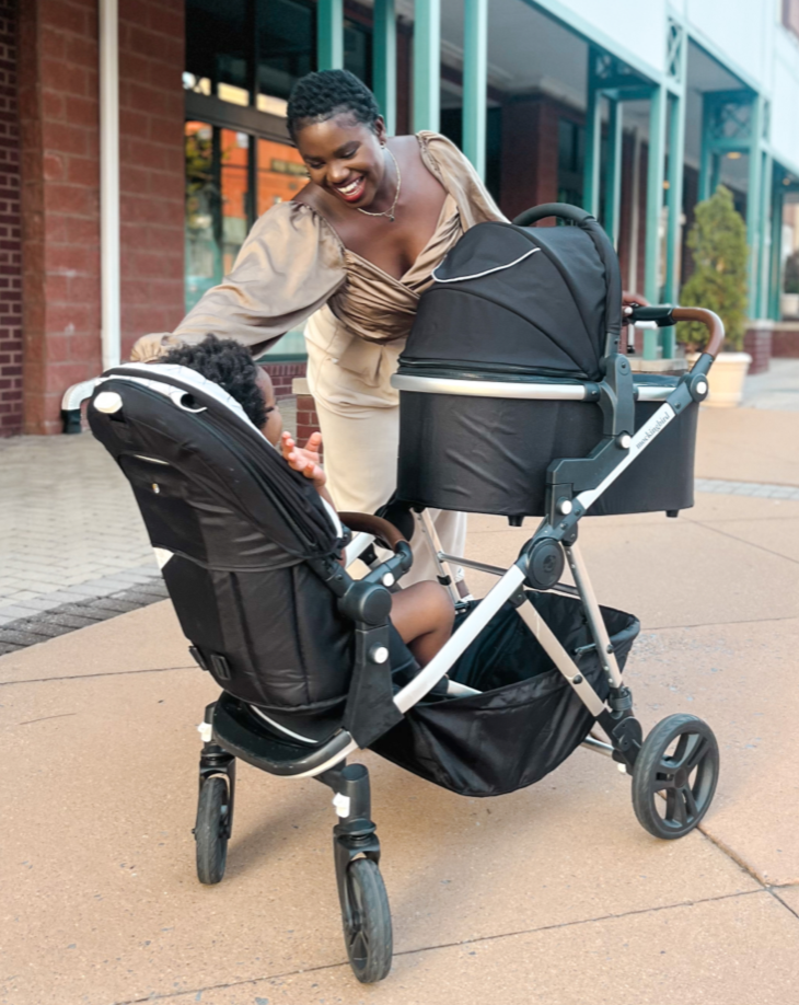 a mom of two adjusting the seat in the mockingbird single to double stroller