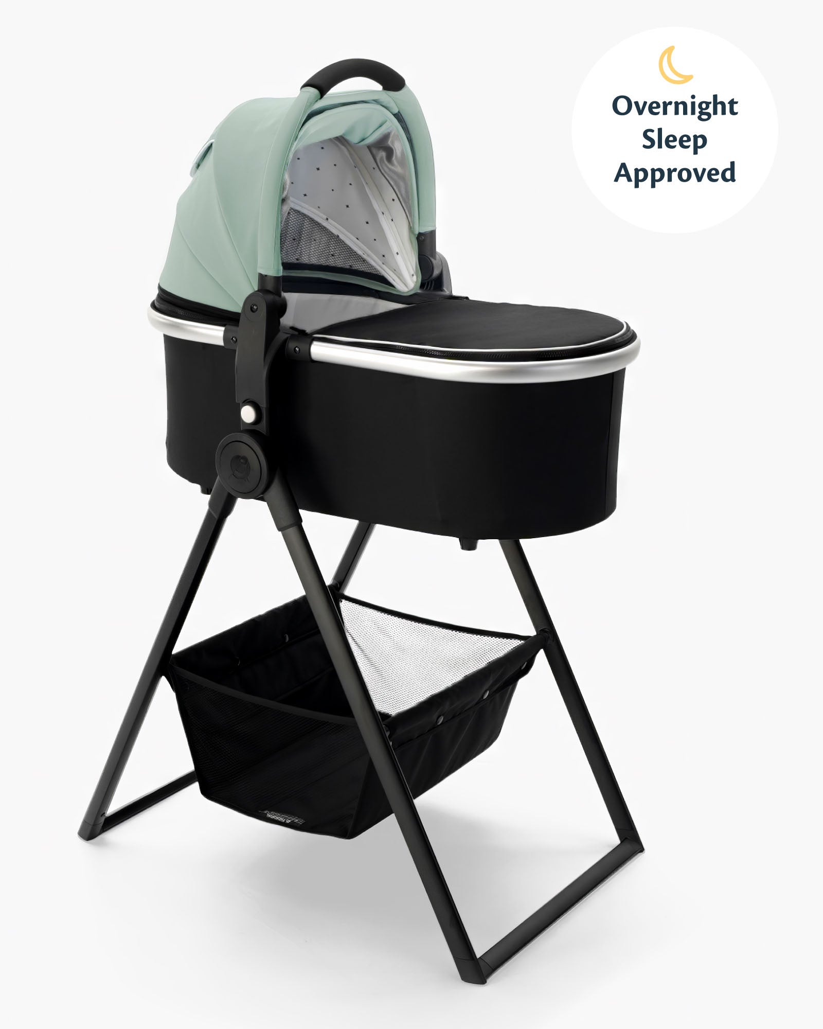 A modern baby bassinet + bassinet stand in mint green and black, equipped with a storage basket, labeled as "overnight sleep approved" #color_sage