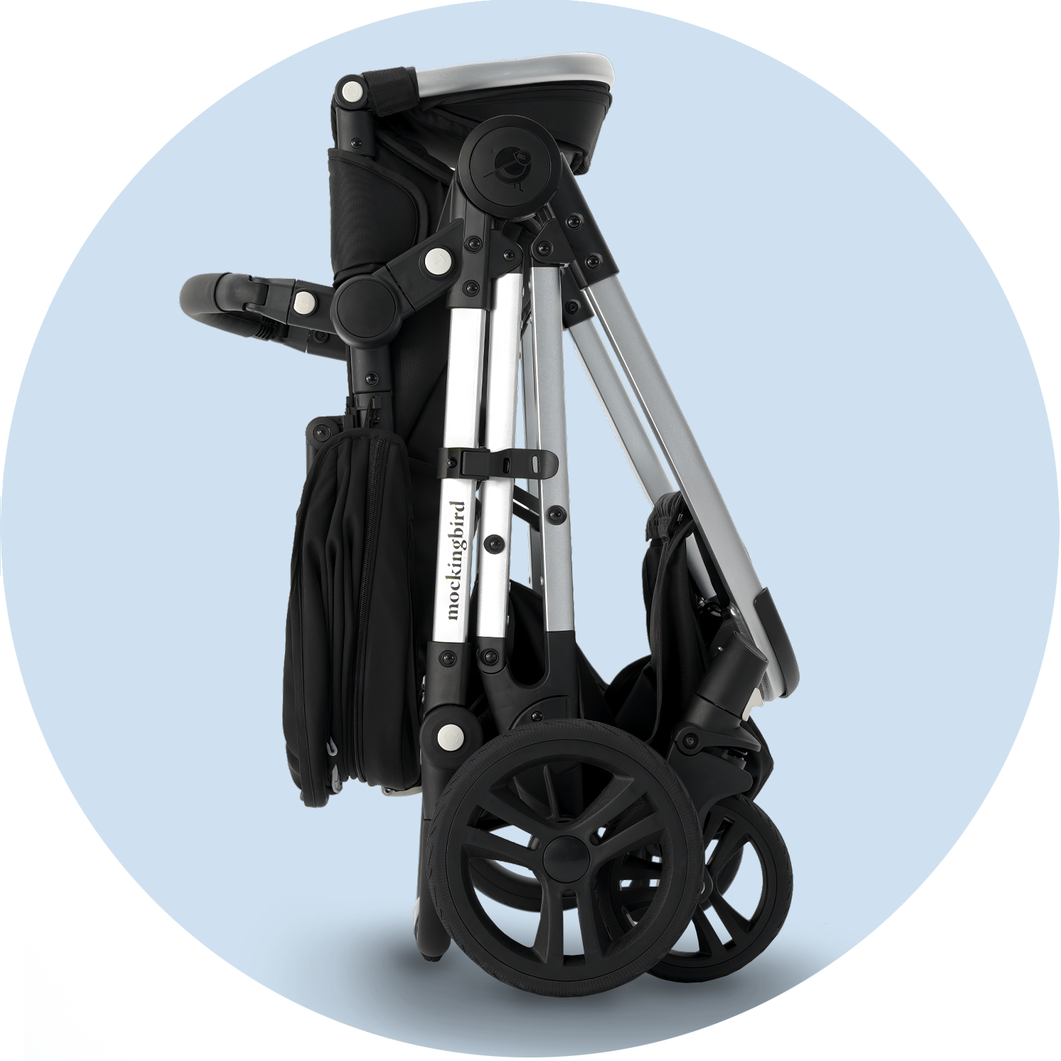 Black and silver collapsible baby stroller against a light blue background.