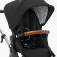 Close-up of a modern black mockingbird-prod Mockingbird stroller with an Extra Stroller Canopy 2.0, brown handlebar, and white frame. #color_black