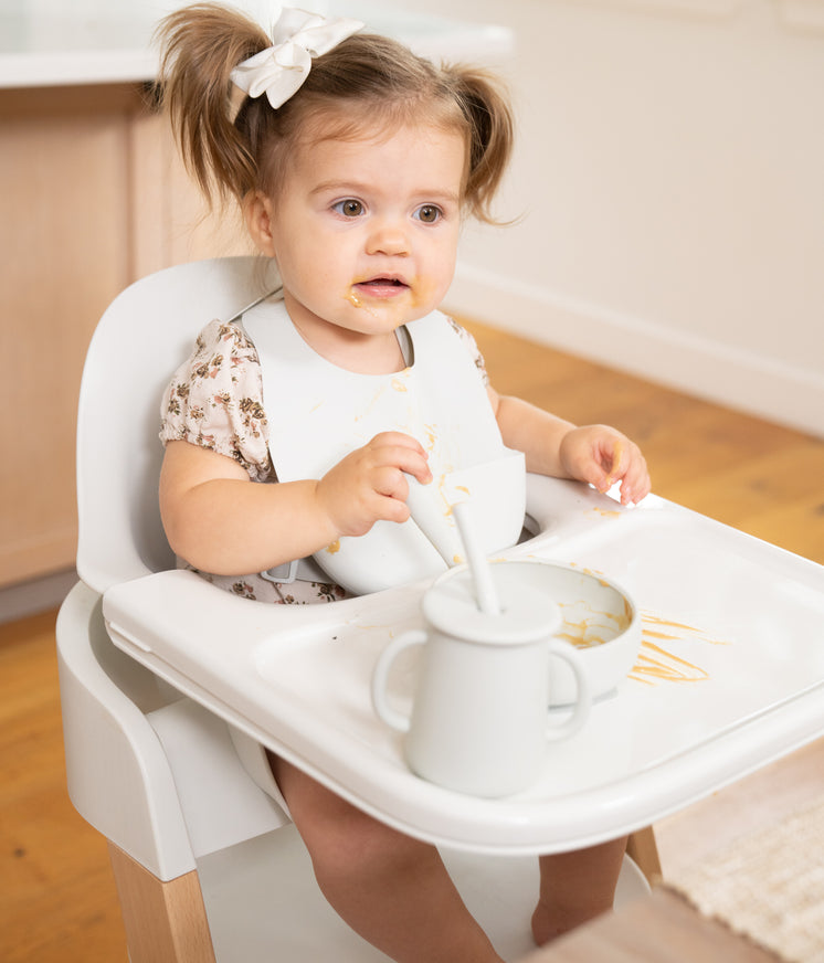 small child eating while sitting in mockingbird high chair in kitchen area