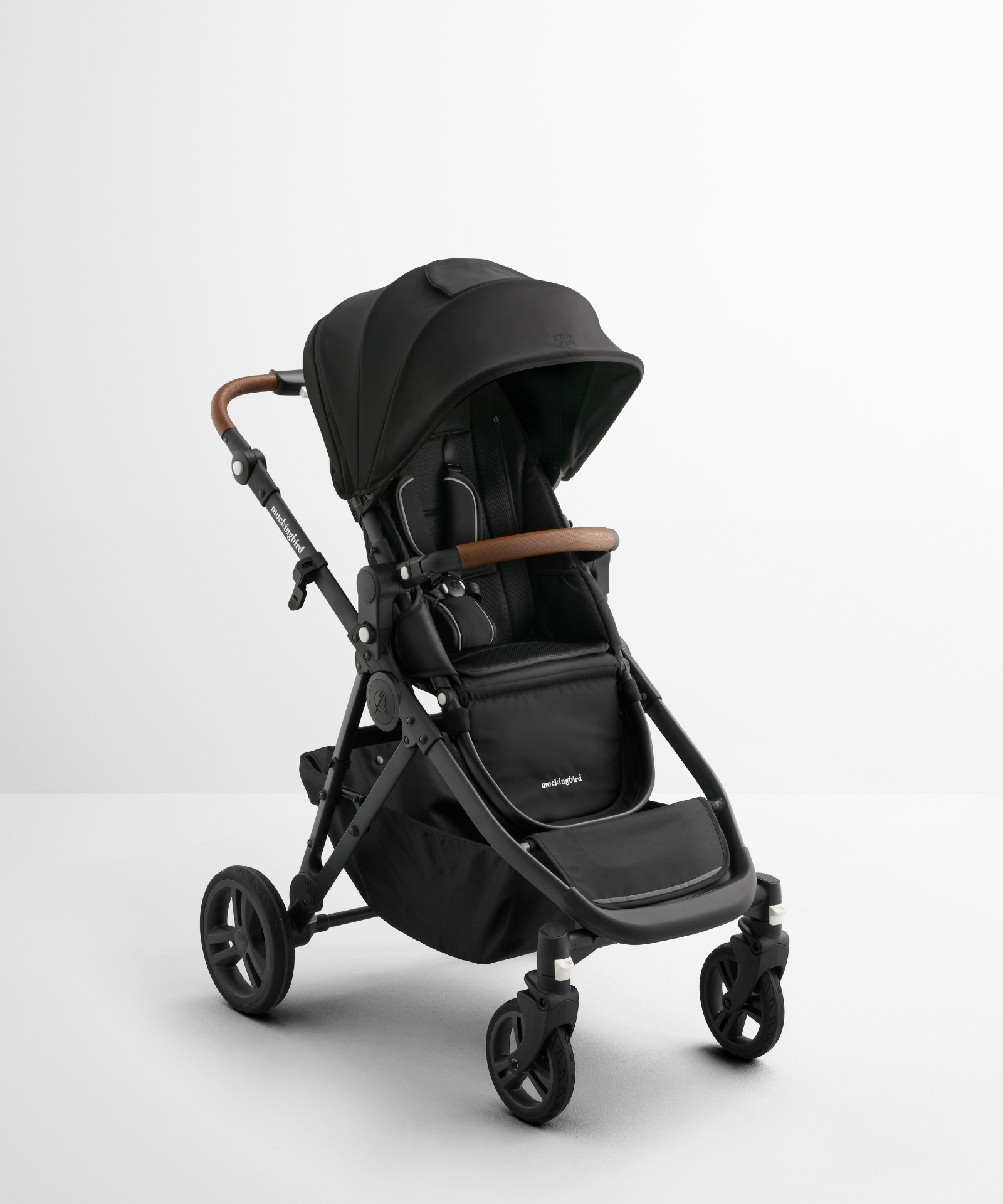The Mockingbird [TEST] Eko Copy - Single-to-Double Stroller 3.0 (Copy) features a black frame with brown handlebar, canopy, and storage basket, shown on a white surface against a plain white background.