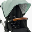 Close-up of a modern mockingbird-prod Mockingbird stroller with a mint green Extra Stroller Canopy 2.0, black seat, and a brown leather handle. #color_sage