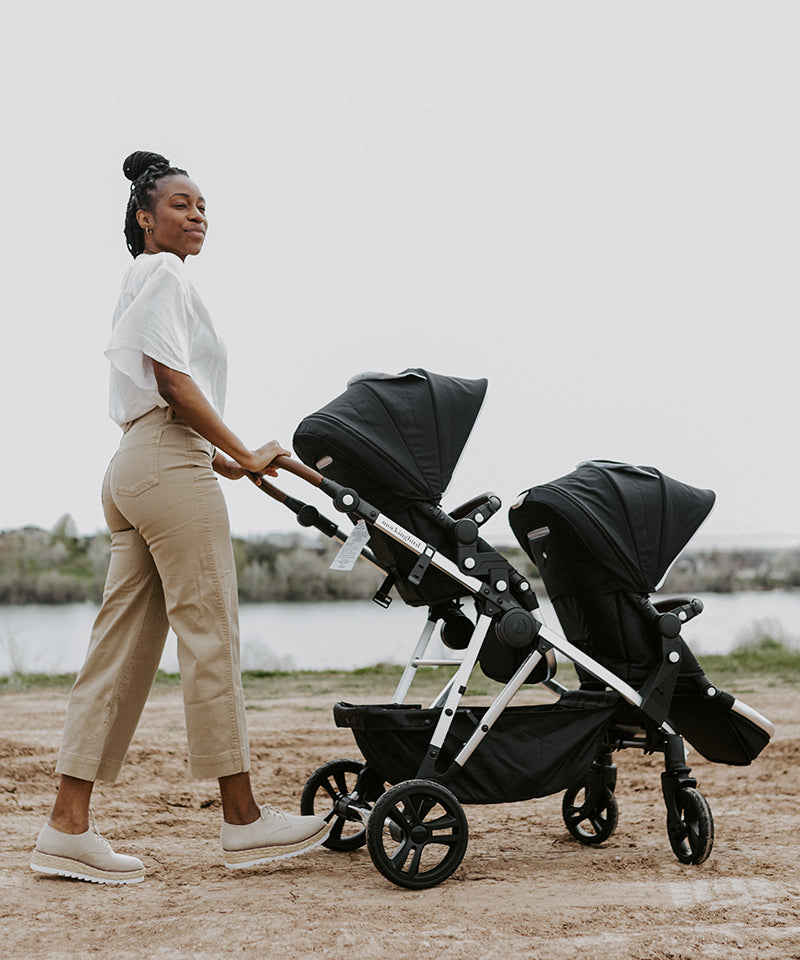 Mom pushing her Mockingbird Single to double stroller at a park